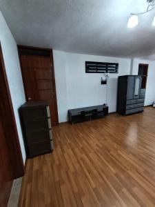 an empty living room with a hard wood floor at Casa en Sur de Quito in Quito +6 photos