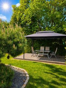 a patio with a table and chairs under an umbrella at Ferienwohnung Mara in Ettringen