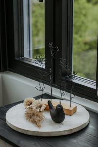 a black bird decoration on a table in front of a window at L'envol des oies in Braives