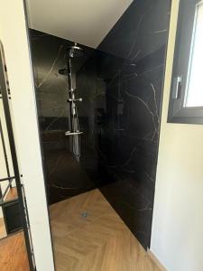 a bathroom with a shower with a black wall at Villa eger in Ruoms