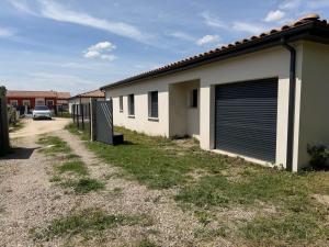 a building with a garage with a car parked next to it at Villa eger in Ruoms