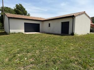 a house with two garage doors in a yard at Villa eger in Ruoms +2 photos