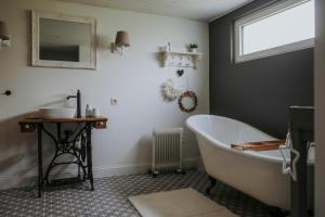 a bathroom with a tub and a sink and a mirror at L'envol des oies in Braives +15 photos