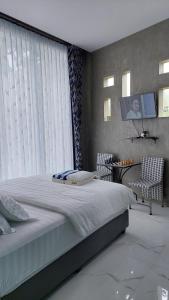 a bedroom with a large bed and a television at The Yoora Villa in Ngadipuro