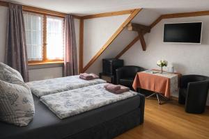 a room with two beds and a table with chairs at Hotel Bären Amriswil in Amriswil