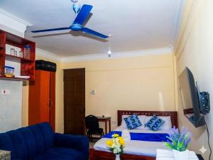 a bedroom with a bed and a ceiling fan at Dorado Homestay, Chaani in Mombasa