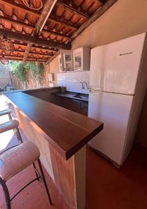 a kitchen with a white refrigerator and a counter at Recanto da harmonia in Ribeirão Preto