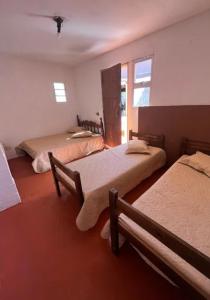 a bedroom with two beds and a mirror at Recanto da harmonia in Ribeirão Preto
