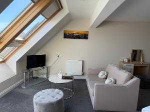 a living room with a couch and a tv at Boathouse Hotel in Hythe