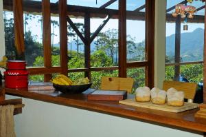 a counter with some bread and bananas on it at Estalagem Terramauá in Visconde De Maua