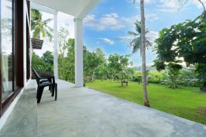 a black chair sitting on a porch looking out at a park at Tranquil Heaven Near Galle & Unawatuna Quiet Stay & Fast WiFi in Galle