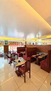 a dining room with tables and chairs in a restaurant at Aira Residency in Vennikulam +11 photos