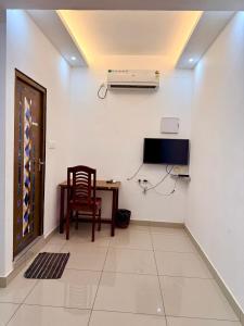 a room with a desk and a television and a chair at Aira Residency in Vennikulam