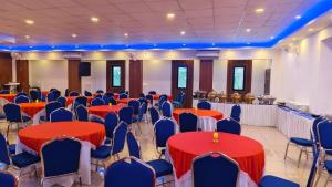 a banquet hall with red tables and blue chairs at Aira Residency in Vennikulam