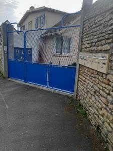 a blue gate in front of a house at Maison Quebec in Bernières-sur-Mer +4 photos