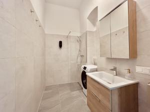 ein weißes Badezimmer mit Waschbecken und Toilette in der Unterkunft SERVUS HOMES Schönbrunn I Top-Lage & Metro in Wien + 33 Fotos