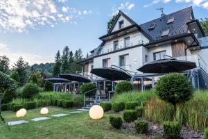 a large building with umbrellas in a garden at NovaWisła Resort & SPA in Wisła