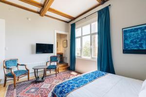a bedroom with a bed and two chairs and a table at Casablu Hotel in Valparaíso