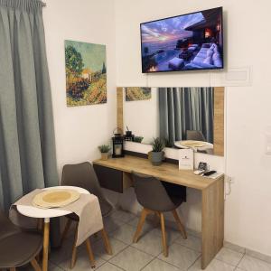 a room with a desk with a tv on the wall at Stelios Studios Sougia in Sougia