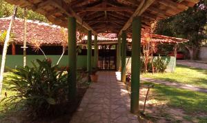 a covered walkway in a yard with a building at Pousada O Povorello - a 1 minuto a pé da Praia Grande da Baía do Sol in Mosqueiro