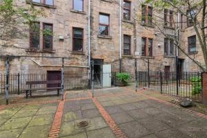 a building with a bench in front of a building at Top Floor West End Flat - 3-Min Walk to Subway - Park Views in Glasgow