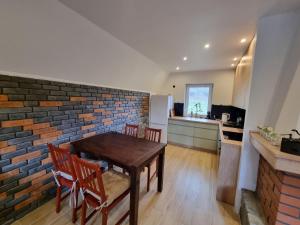 a kitchen with a table and chairs and a brick wall at Domek pod Widetą in Smerek