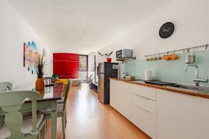 a kitchen with white cabinets and a table and a counter at Beach LOFT Tabaiba in Tabaiba
