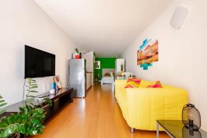 a living room with a yellow couch and a tv at Beach LOFT Tabaiba in Tabaiba