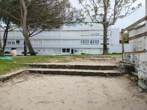 a building with stairs in front of a building at El Pinar Beach in Comillas