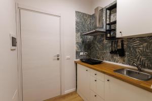 a kitchen with a white door and a sink at HARBOR BREEZE Trapani in Trapani