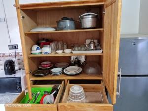 a kitchen cabinet filled with dishes and pots and pans at Cabanon plage david in Bouznika