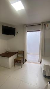 a bedroom with a bed and a tv and a window at Pousada Valhacouto II in Paraty