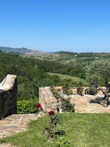 a stone wall with flowers in a garden at Apartma Suzy in Pobegi