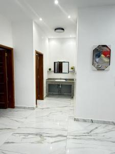 a room with white walls and a white tile floor at Dar AL-HANAA in Nouakchott