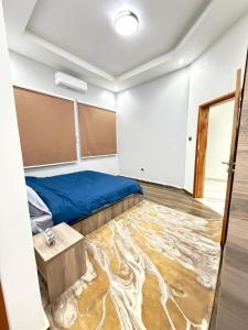 a room with a bed and a table on a carpet at Dar AL-HANAA in Nouakchott