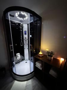 a bathroom with a shower with a large mirror at Rina Apartments, Cozy Riverside Stay in Luče, near Logar Valley in Luče +14 photos