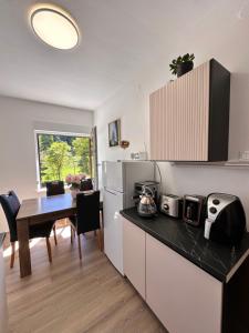 a kitchen and dining room with a table and refrigerator at Rina Apartments, Cozy Riverside Stay in Luče, near Logar Valley in Luče
