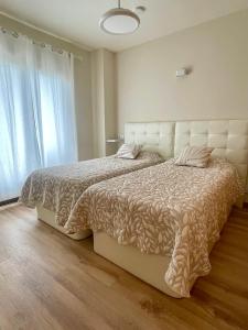 a bedroom with two beds and a large window at Apartamento en Moraira Centro con Piscina in Moraira +28 photos