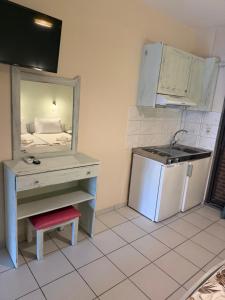 a kitchen with a sink and a desk with a stove at Nikis studios in Skala Sotiros +34 photos