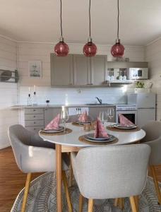 a kitchen with a table and chairs with pink pillows on it at Fjordheart Srbvg 1 in Hyllestad