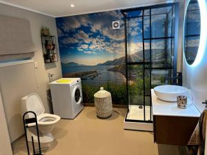 a bathroom with a sink and a toilet and a window at Fjordheart Srbvg 1 in Hyllestad