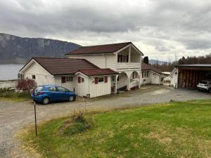 a house with a car parked in front of it at Fjordheart Srbvg 1 in Hyllestad