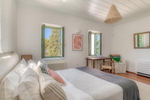 a bedroom with a bed and a desk and windows at Villa Thimari in Protorgia