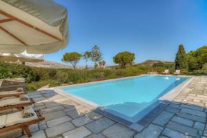a large swimming pool with an umbrella and chairs at Villa Thimari in Protorgia +10 photos
