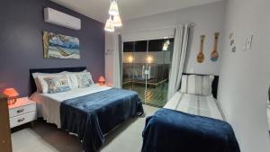 a bedroom with two beds and a window at Casa piscina privativa e Área Gourmet - Condomínio 24 hs in Araruama +47 photos