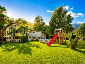 a yard with a slide and a playground at Parkhotel Emmaus - Casa del Sole in Ascona