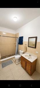a bathroom with a toilet and a sink and a tub at Sea View Escape in The Valley +22 photos