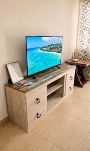 a flat screen tv sitting on top of a wooden entertainment center at Sea View Escape in The Valley