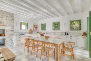 a kitchen with white cabinets and a table and chairs at Villa Thimari in Protorgia