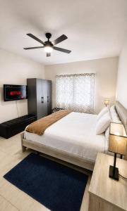 a bedroom with a large bed with a ceiling fan at Sea View Escape in The Valley